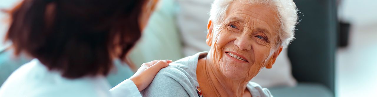 A smiling, senior woman being consulted by a doctor