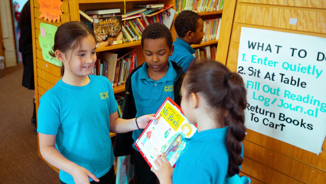 Students in school library holding books