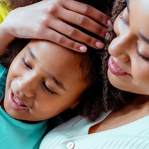 Woman holding her daughter close in an embrace