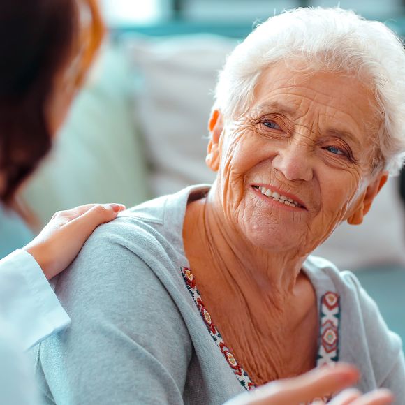 Senior woman smiling and being consulted by doctor