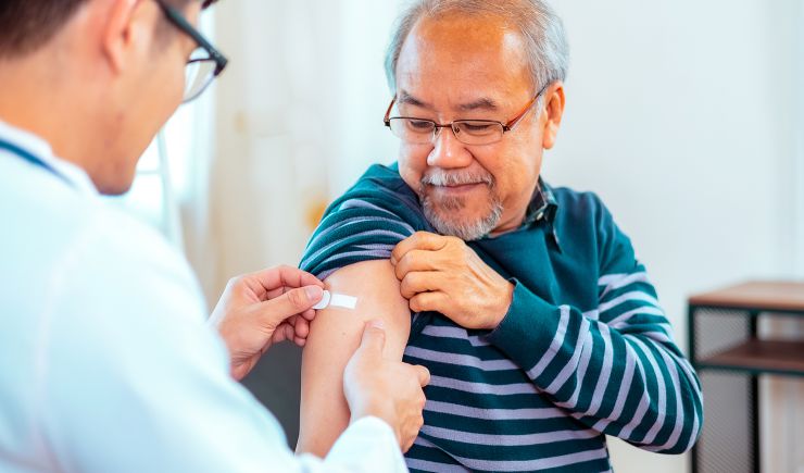 A man getting prepped for a vaccine by a doctor