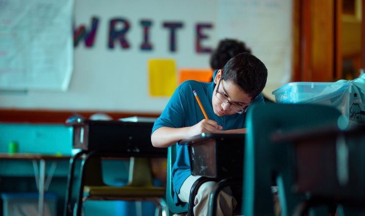 Child sitting at desk working on school work in classroom