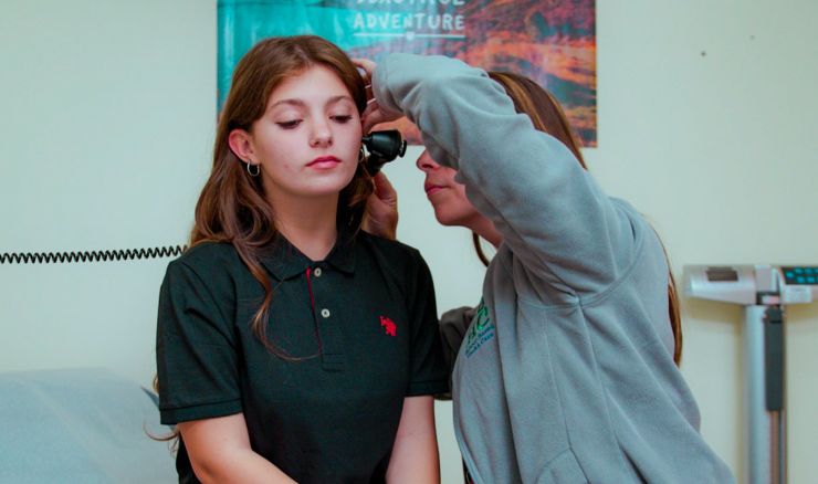 Teenage student getting ears checked at school clinic